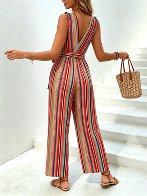 Striped wide-leg jumpsuit with tie waist, V-neck, and tie shoulders in orange and red hues.