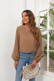 Camel V-neck blouse with sheer pom-pom detail balloon sleeves.
