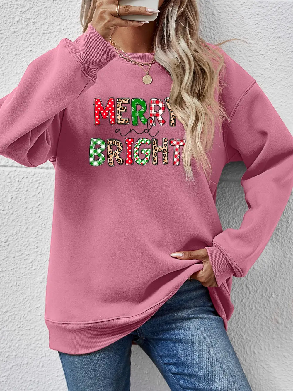 Blush Pink sweatshirt with "Merry and Bright" graphic featuring festive patterns.