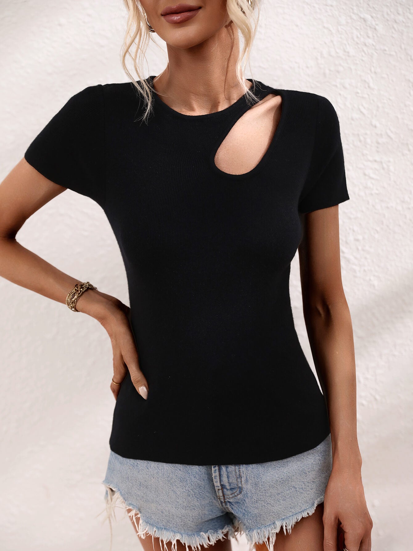 Black knit t-shirt with a cutout detail on the neckline and short sleeves.