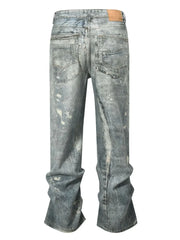 Distressed wide-leg jeans in medium wash denim with painterly details and a relaxed fit.