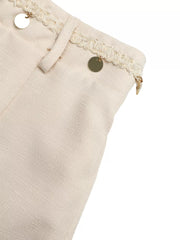 Embellished linen two-piece set in cream with decorative trim and gold coin details.