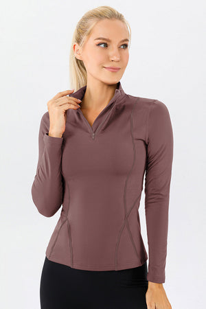 Athleisure zip-neck top in dusty pink with seam details and long sleeves.