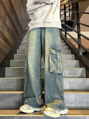 Men's vintage-inspired wide-leg cargo jeans in faded blue denim with large side pockets.