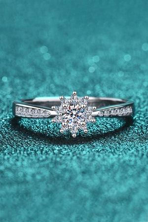 Silver moissanite ring with a starburst cluster center and pave band.