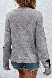 Gray knit jumper with black star details on sleeves, crew neck, long sleeves.