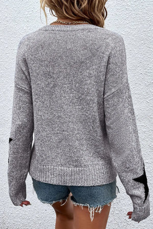 Gray knit jumper with black star details on sleeves, crew neck, long sleeves.
