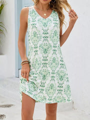Botanical print mini dress in white with green floral pattern and crochet detail on shoulders.
