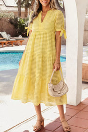 Yellow gingham midi dress with V-neck, tiered skirt, and tie-sleeve details.