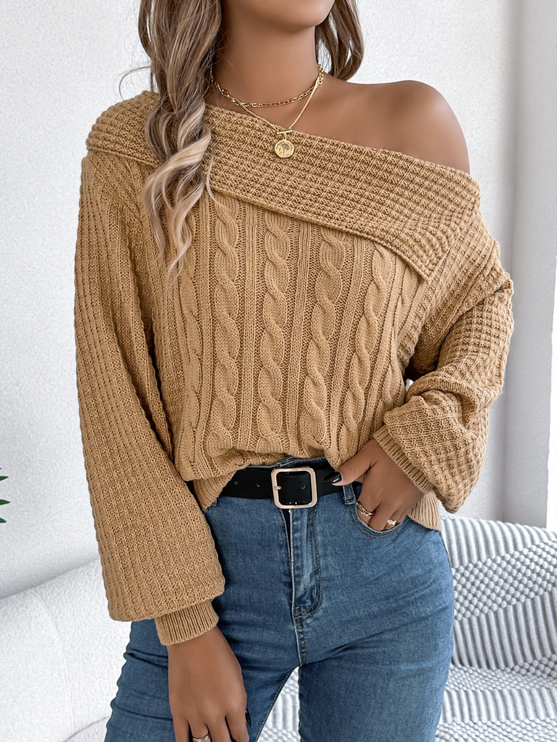 Camel off-shoulder cable knit pullover sweater with asymmetrical neckline and long sleeves.