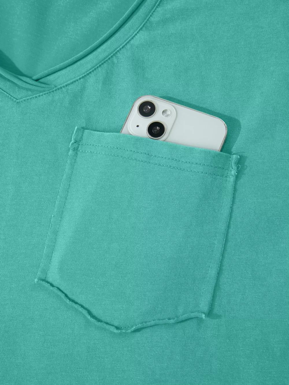 Teal mineral wash cotton tee with V-neck and chest pocket holding a smartphone.