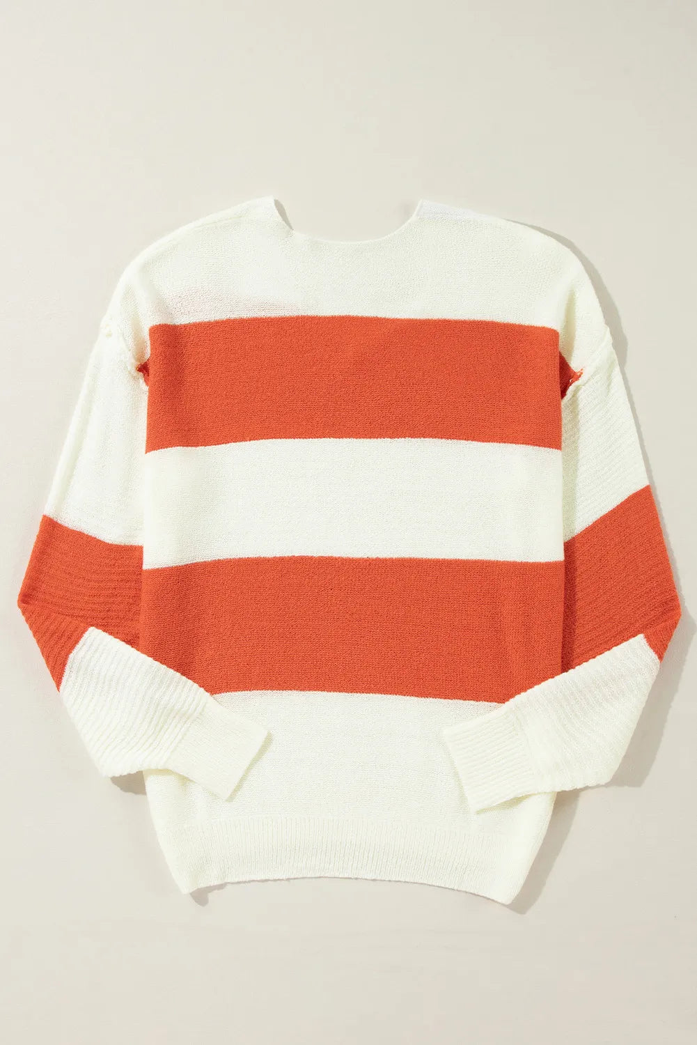 Orange and white striped V-neck knit sweater with a slouchy fit