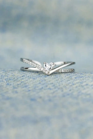 Silver V-shaped ring with diamond accents and a heart-shaped center stone.