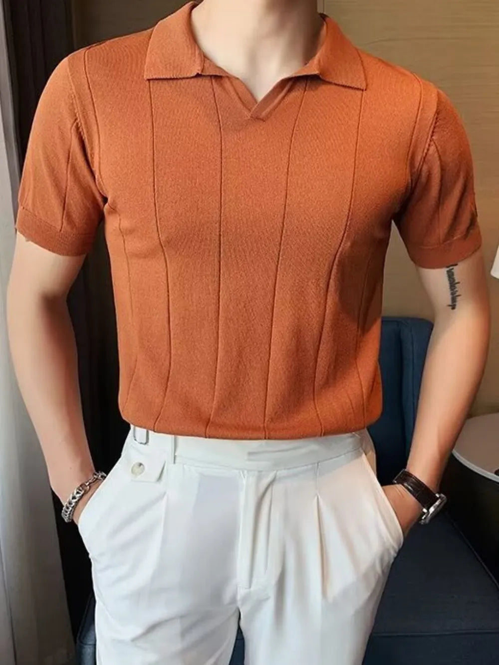 Orange textured knit polo shirt with vertical ribbing and short sleeves.