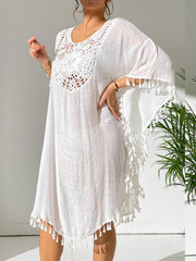 White crochet yoke kaftan dress with tassel trim and wide sleeves.