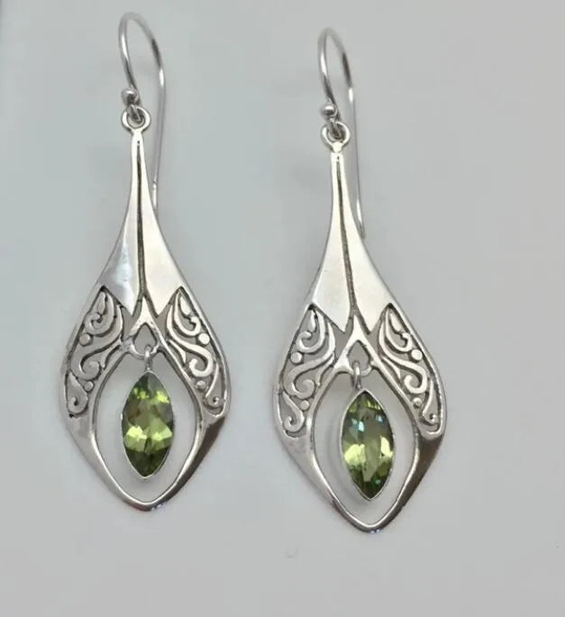 Silver filigree pear-drop earrings with marquise-cut peridot stones.