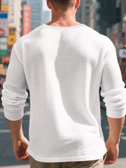 White waffle knit henley t-shirt with long sleeves, crew neck, and relaxed fit.
