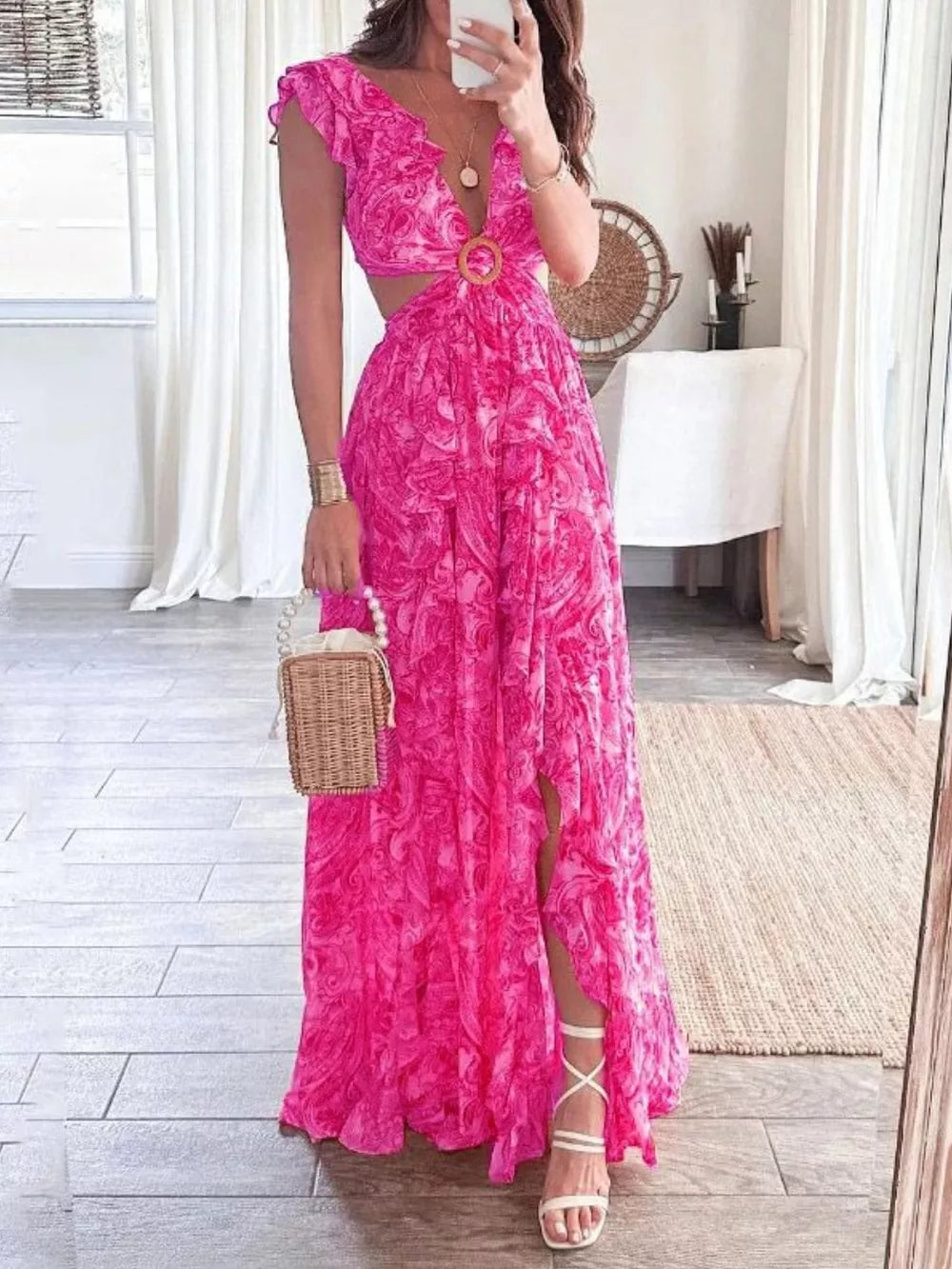 Pink ruffled V-neck maxi dress with cut-outs and a wood ring detail.