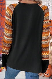 Black raglan tee with Aztec print sleeves in orange and tan.