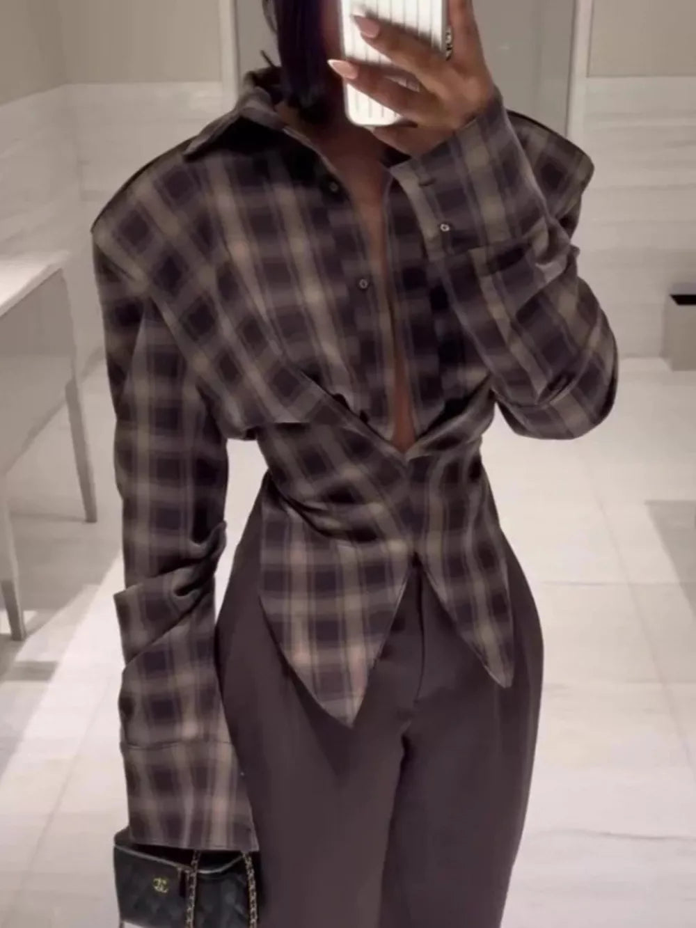Chic ruched plaid button-down shirt with buttoned cuffs and a draped front.