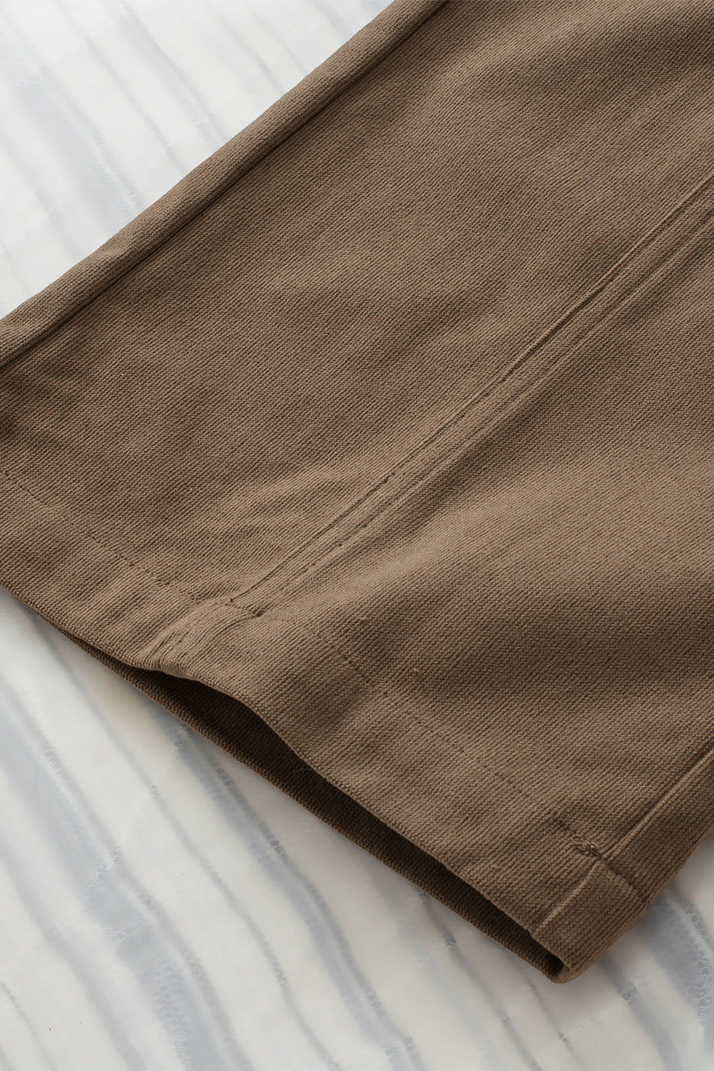 Caramel seamed front wide leg trousers detail showing stitching and fabric texture.