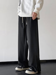 Men's black relaxed fit sweatpants with drawstring waist and side slits.