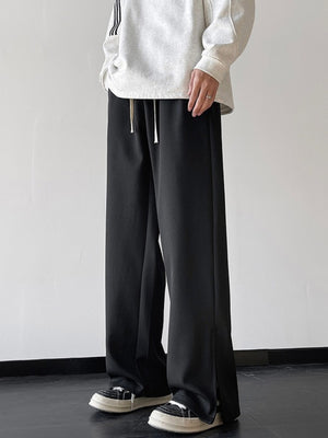 Men's black relaxed fit sweatpants with drawstring waist and side slits.