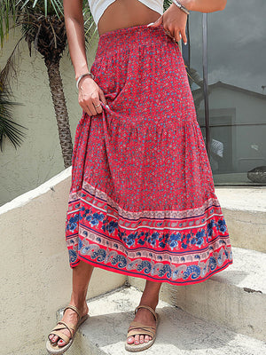 Bohemian tiered midi skirt in red with a floral print and embroidered border.