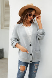 Grey waffle knit oversized button-front cardigan with pockets and black buttons.
