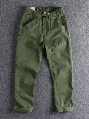 Men's green elastic waist cargo pants with button closure and cuffed hems.