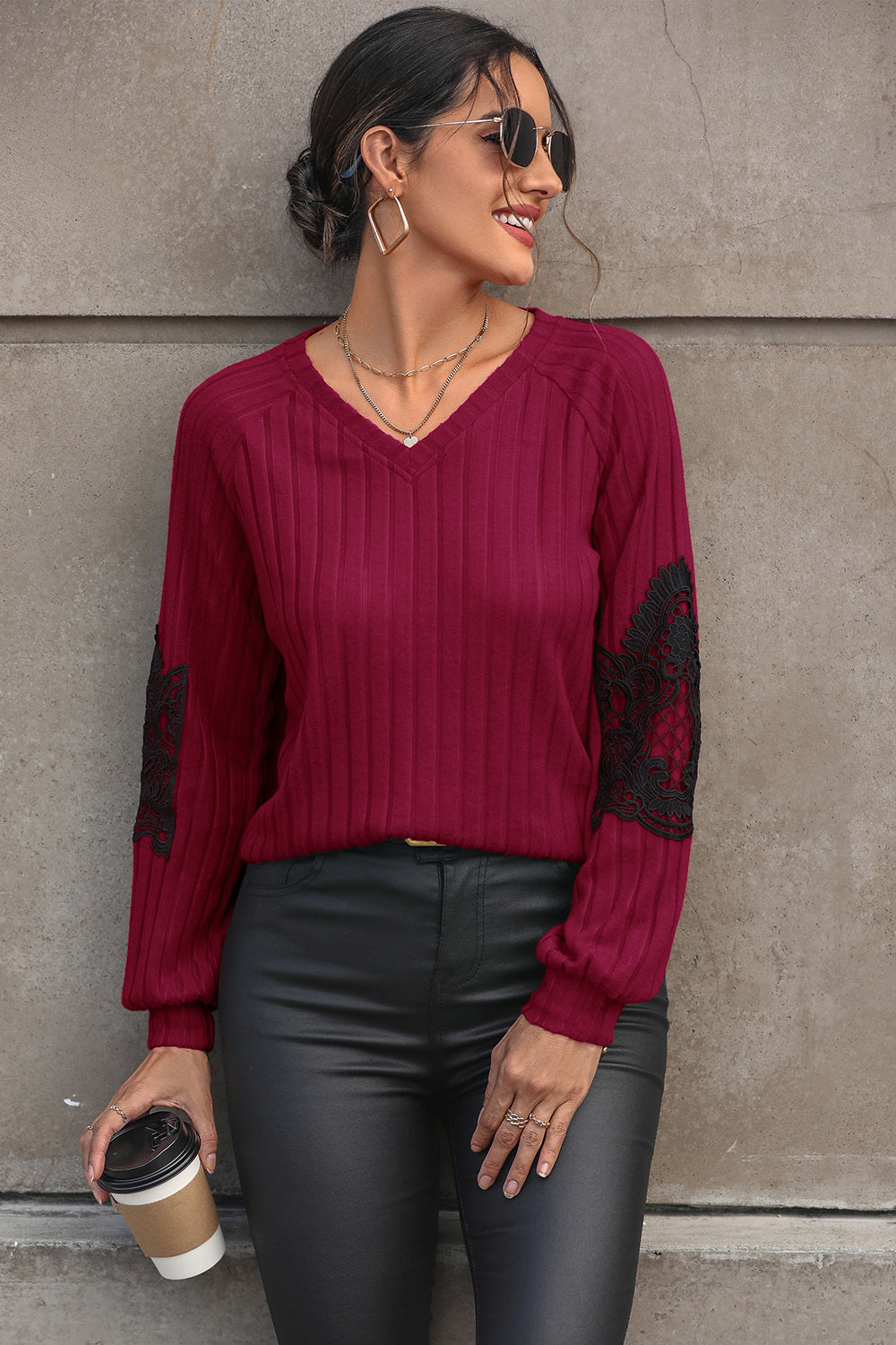 Deep red ribbed knit sweater with black lace appliqué on the sleeves and V-neck.