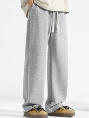 Men's grey drawstring sweatpants with a relaxed fit and snap button ankle detail.