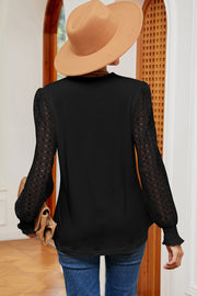 Black knit top with lace sleeves and ruffled cuffs.