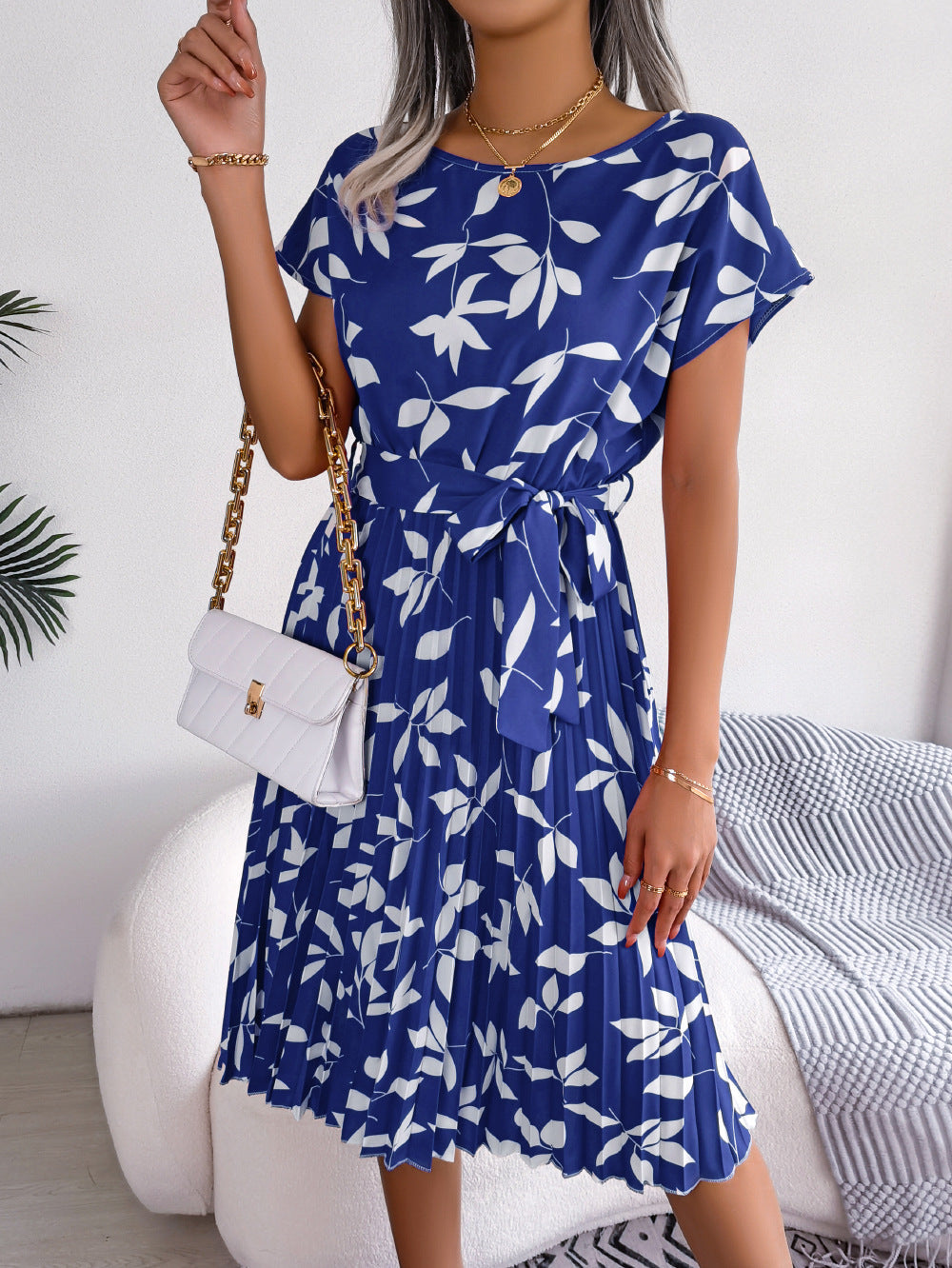 Blue leaf print midi dress with short sleeves, tie waist, and pleated skirt.