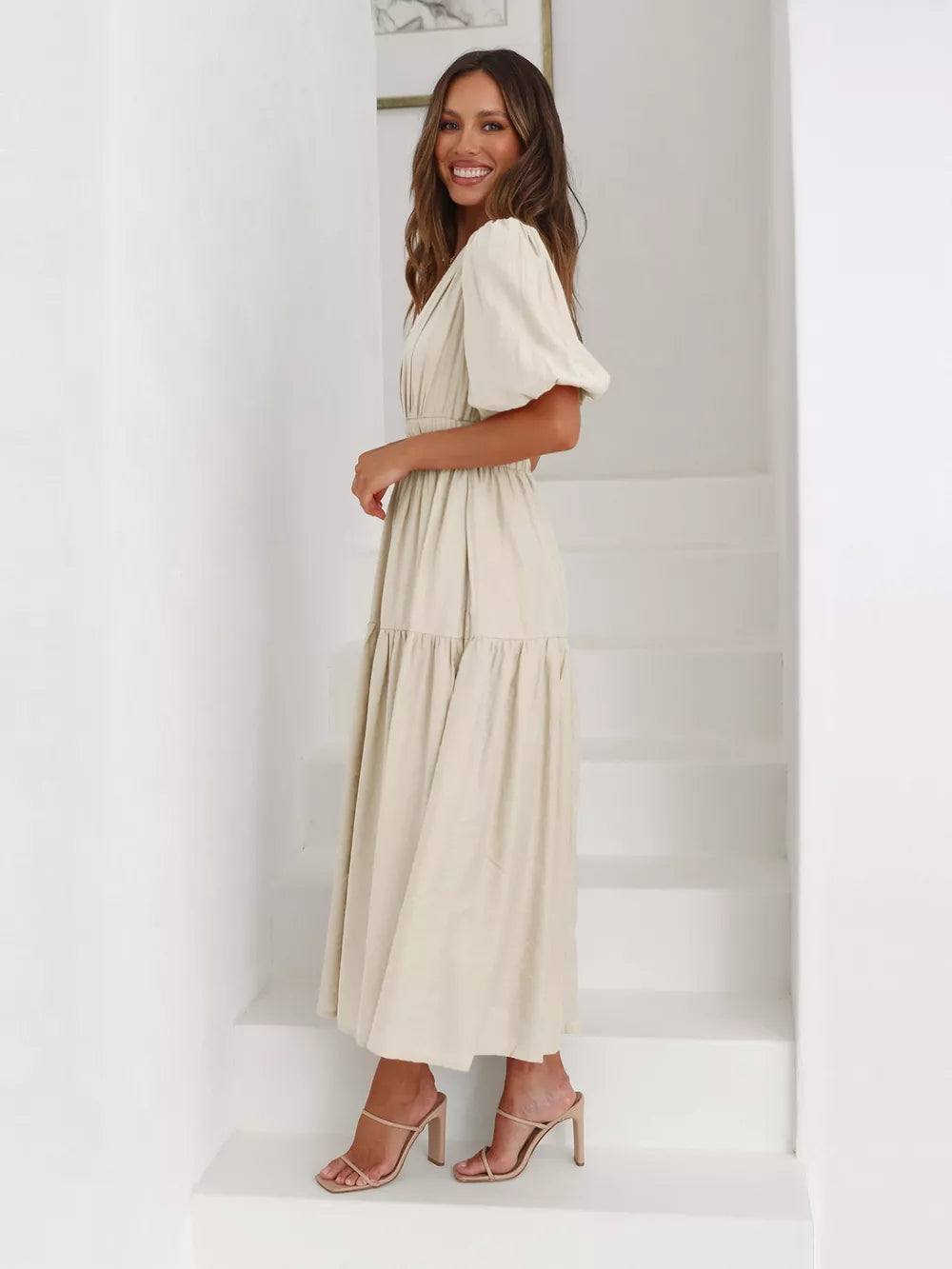 Beige midi dress with puff sleeves, V-neck, and tiered skirt.
