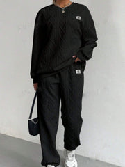 Black cable knit loungewear set with crew neck sweater and wide leg pants.