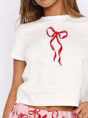 White short sleeve tee with a red bow graphic, paired with pink patterned lounge shorts.