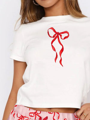 White short sleeve tee with a red bow graphic, paired with pink patterned lounge shorts.