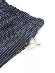 Blue striped wide-leg pants with elastic waistband and pocket detail, showing gold-rimmed glasses.