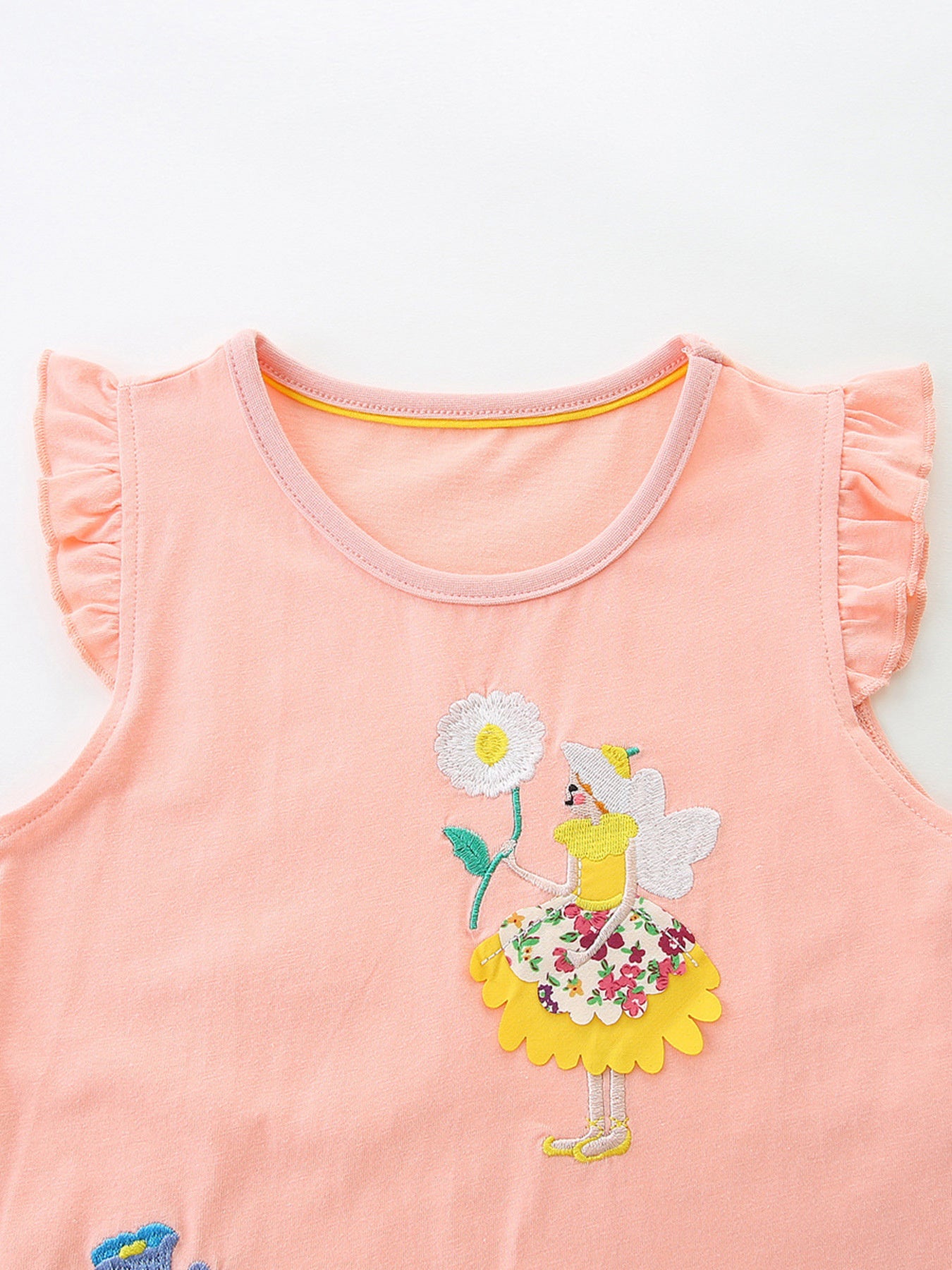 Peach cotton toddler dress with fairy embroidery and ruffled sleeves.