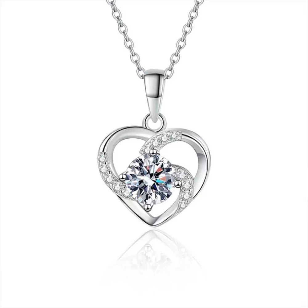 Silver heart pendant necklace with a large round cubic zirconia and small accent stones.