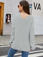 Light grey ribbed knit sweater with V-neck and subtle sleeve detail.