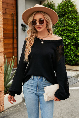 Black knit sweater with off-the-shoulder neckline and sheer slit detail on sleeves.