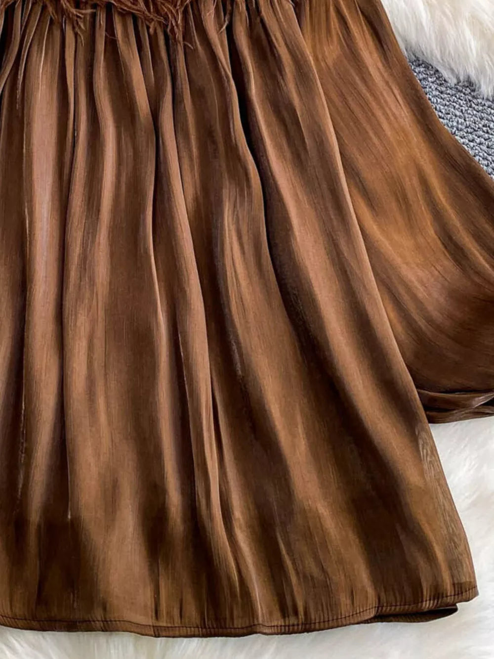 Brown sheer blouse with feather trim and pleated fabric detail