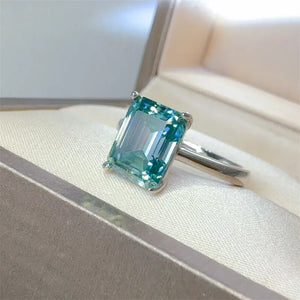 Emerald cut teal moissanite ring in silver with a solitaire setting.