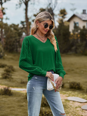 Green v-neck blouse with swiss dot puff sleeves and a relaxed fit