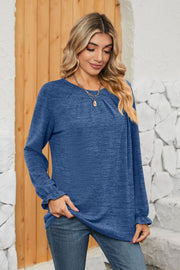 Light blue knit top with pleated yoke and ruffled cuffs.
