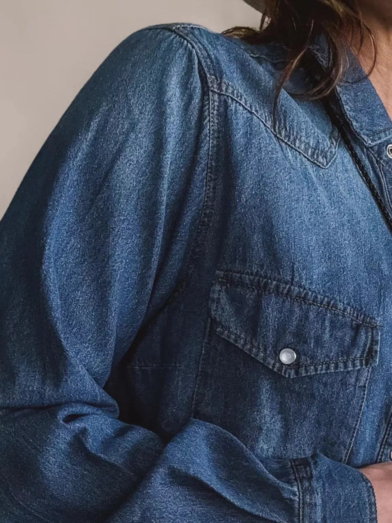 Classic blue denim button-down shirt with two chest pockets and button details.