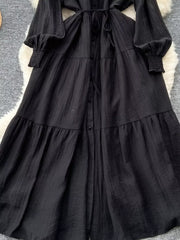 Black tiered long sleeve button-down midi dress with cinched cuffs and tie waist