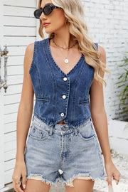 Denim cropped vest in medium wash with V-neck, button front, and two chest pockets.